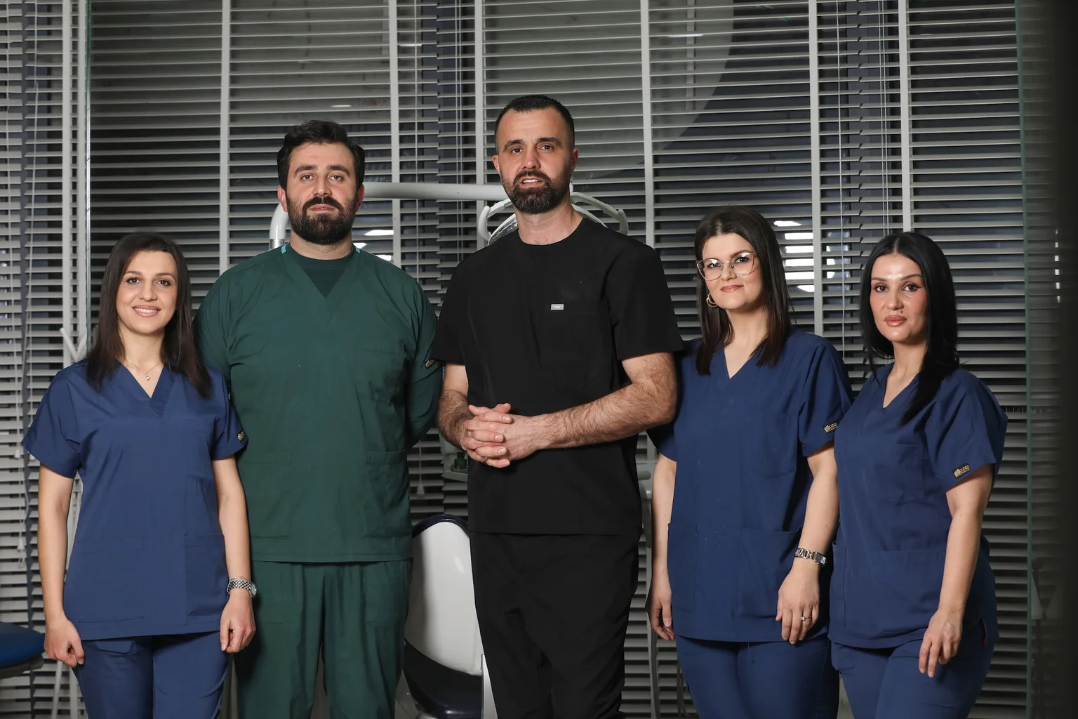 Ekip profesional dentar në klinikë moderne, grup i larmishëm dentistësh dhe stafit